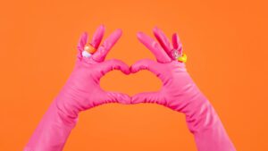 Femme de ménage faisant un coeur avec ses gants de ménage - tarif femme de ménage