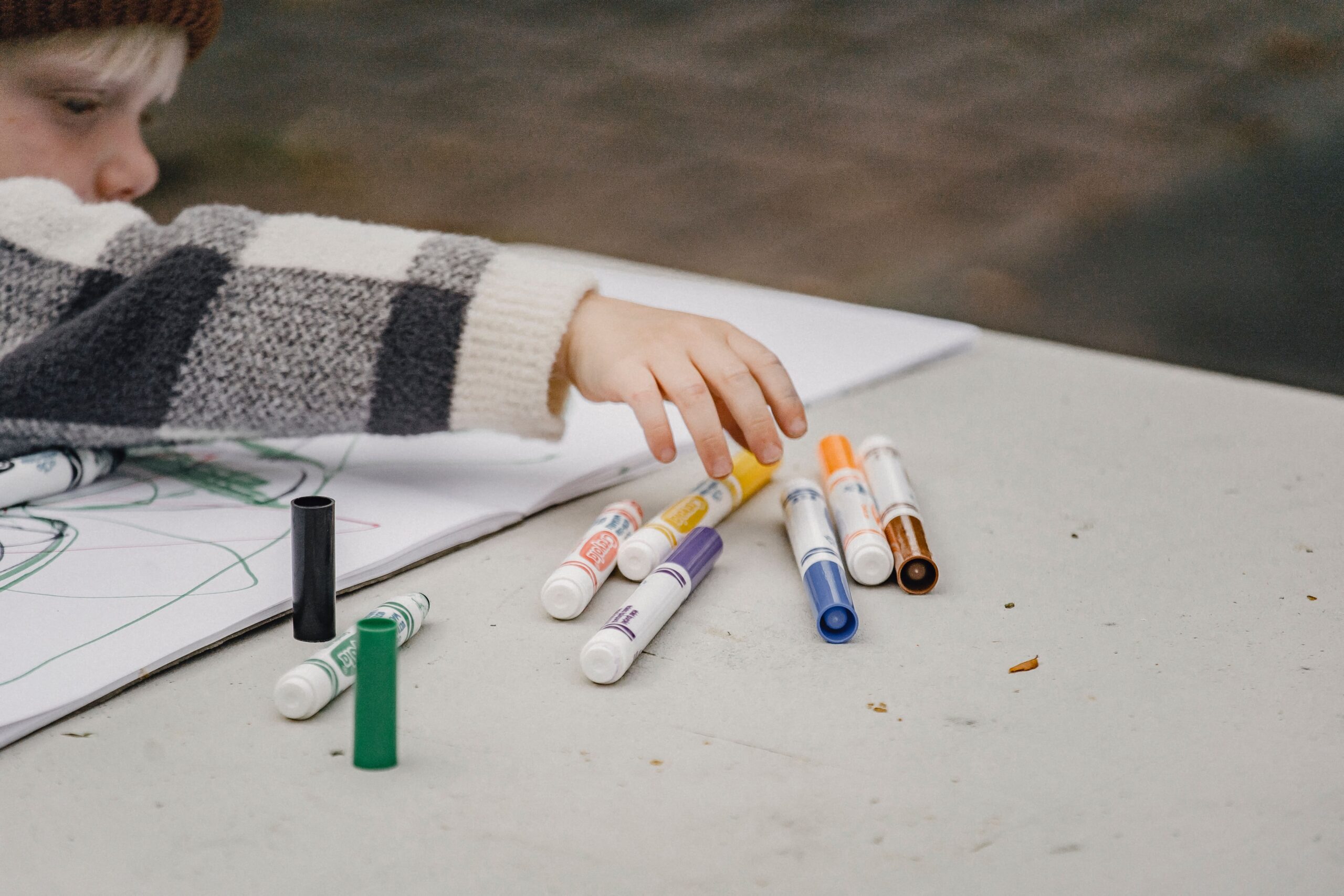 une main d'enfant qui prend des feutres