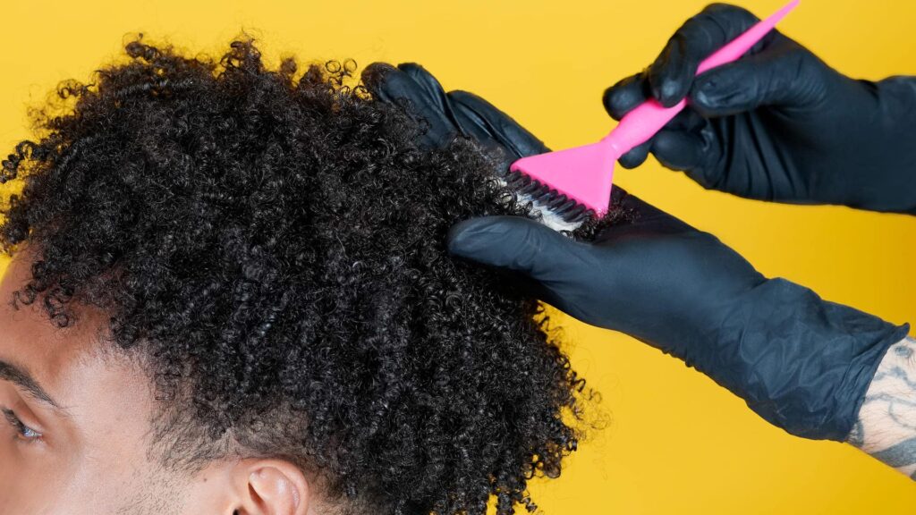 Un homme se faisant faire une couleur par un coiffeur à domicile