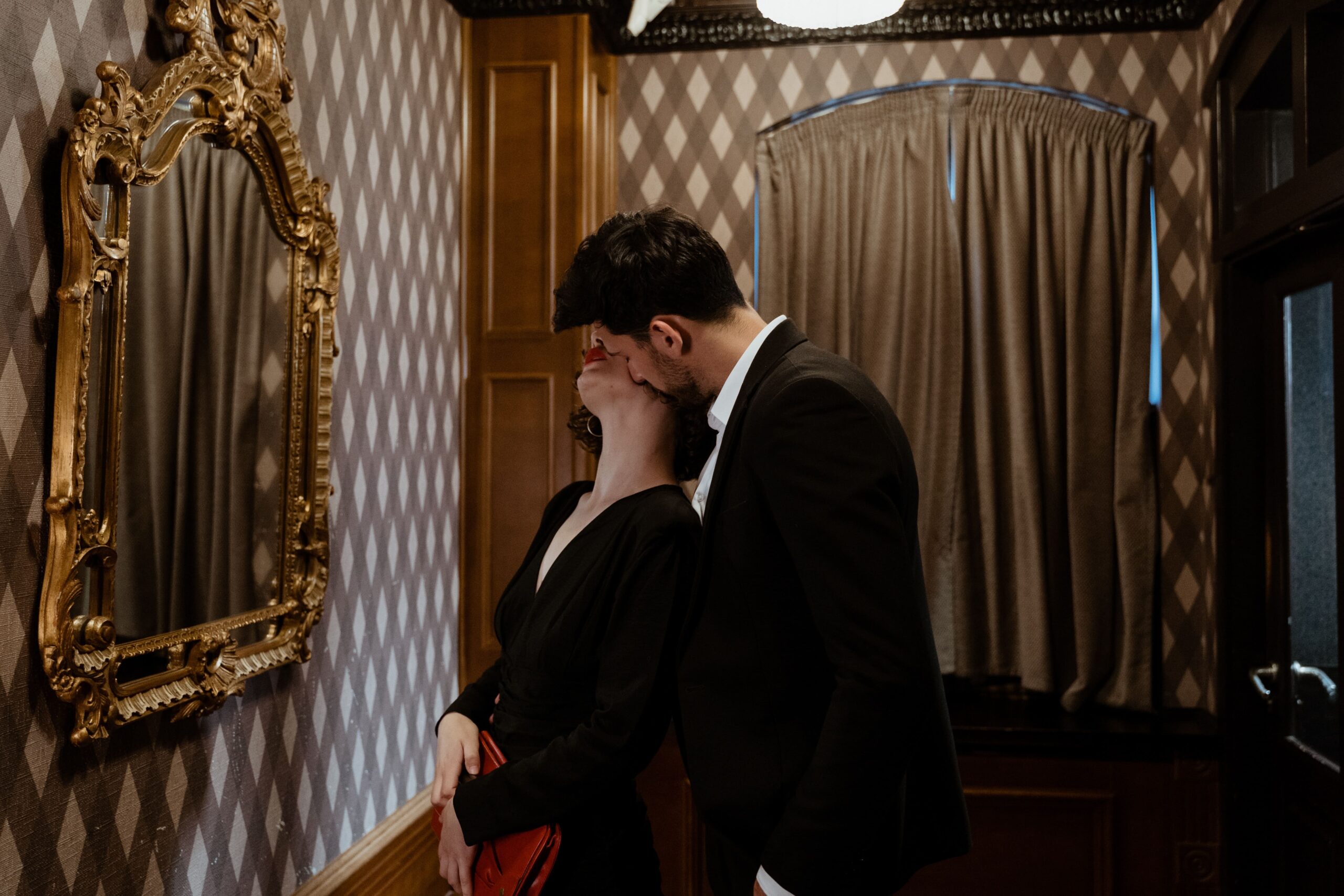 un couple qui s'embrasse face à un miroir 