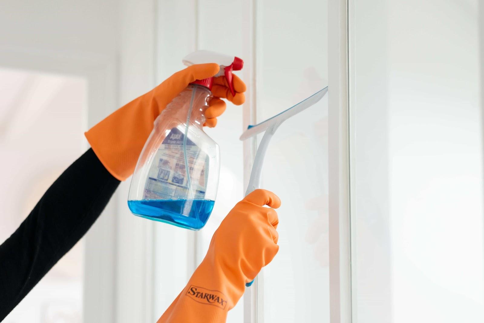 une femme de menage nettoye une baie vitree