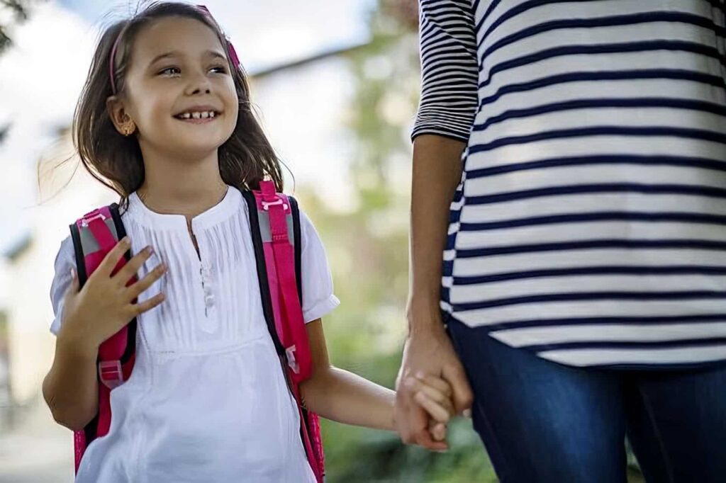 sortie d'ecole - une nounou ramène une petite fille de l'école jusqu'à chez elle