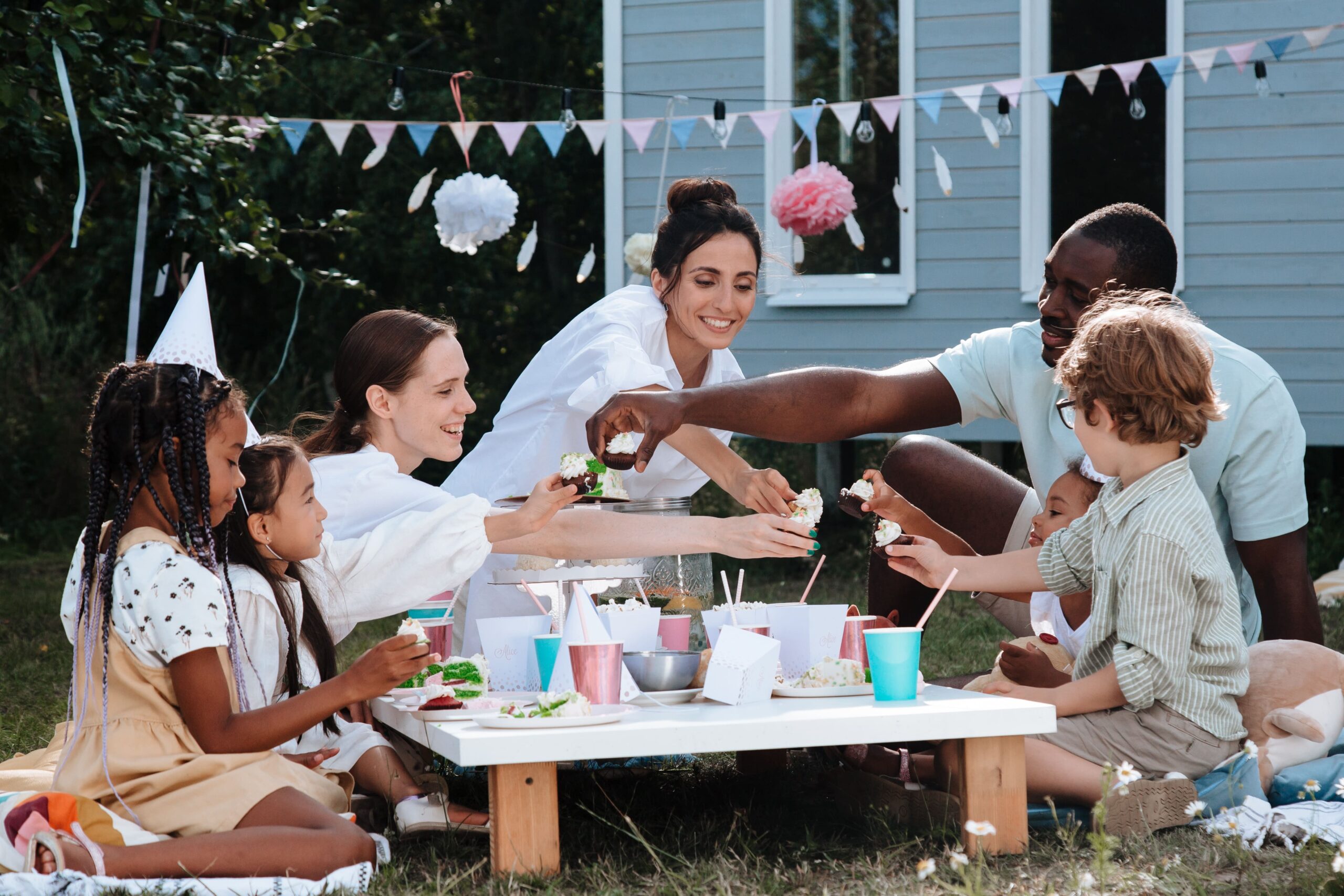 une famille autour d'une table de jardin en plastique